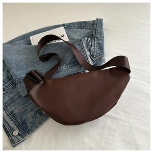 Detail of dark brown crescent crossbody bag showing smooth PU leather and nylon strap