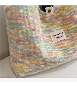 Dettaglio della borsa tote in peluche a righe colorate con etichetta e bottone a pressione