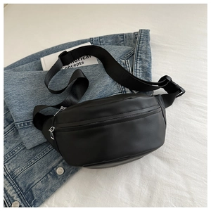 Detail of a black nylon crossbody waist bag with dual zippers and adjustable strap