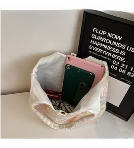 Interno spazioso della borsa tote in maglia colorata contenente due tablet e accessori