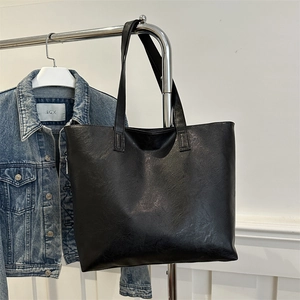 Minimalist black pebbled leather tote bag with dual long shoulder straps for daily commute