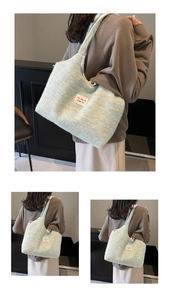 Dettaglio della consistenza morbida di una borsa tote colorata con etichetta del marchio