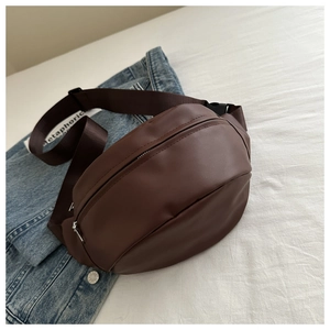 Detail of a brown PU leather waist bag with a zip closure on a denim jacket background