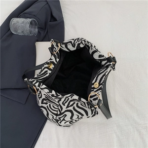 Large zebra print tote bag with black leather straps and gold magnetic closure hardware