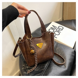 Close-up of brown vintage bucket bag with marble texture and metal bell pendant
