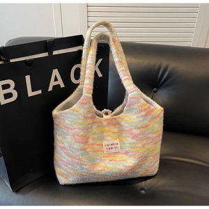 Dettaglio della borsa in maglia arcobaleno con morbida trama in mohair e logo ricamato