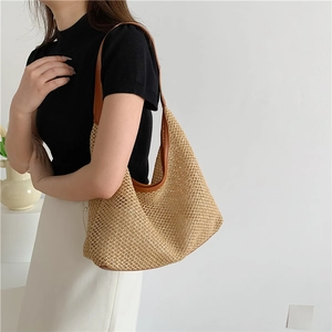 Handwoven straw tote bag with brown leather trim shown on model for summer beach vacations