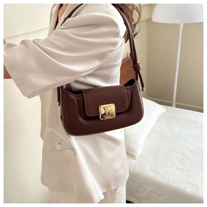 Détail du sac baguette marron foncé avec boucle dorée et lanière à nœud