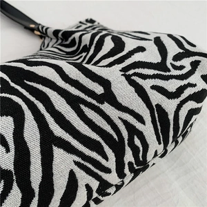 Large zebra print canvas tote bag with black handles and woven texture details