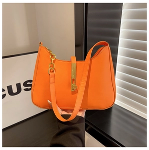 Detail der orangefarbenen PU-Ledertasche mit Goldkette und vertikalem Metallverschluss