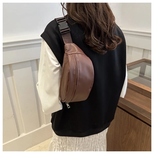 Detail of minimalist dark brown leather crescent waist bag with adjustable nylon strap