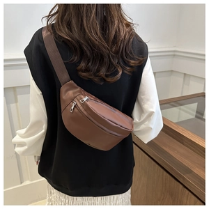 Rear view of a model wearing the brown leather crossbody fanny pack with wide strap