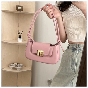Détail du sac baguette rose avec boucle dorée et texture cuir lisse élégante