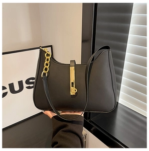 Details einer schwarzen matten PU-Handtasche mit goldenem Metallschloss und Kettenriemen