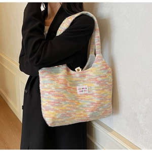 Dettaglio borsa shopper in maglia con filato sfumato e etichetta del marchio