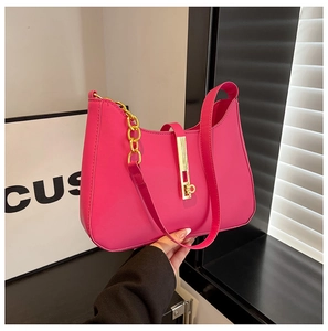 Detail der pinkfarbenen PU-Leder-Schultertasche mit goldener Schnalle und grober Kette