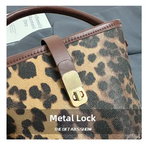 Close-up of golden metal rectangular twist lock and leopard print pattern on the handbag
