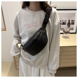 Detailed shot of a black minimalist crescent sling bag with wide strap and buckle