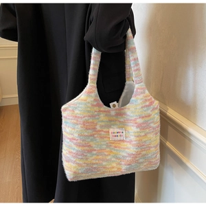 Dettaglio della borsa in maglia colorata con chiusura magnetica e trame arcobaleno