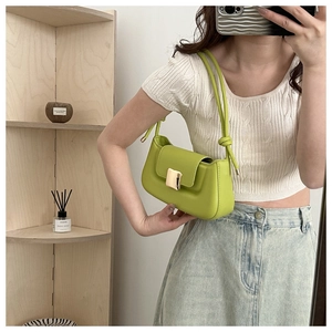 Détail d'un sac baguette vert citron en cuir avec bandoulière nouée et boucle dorée
