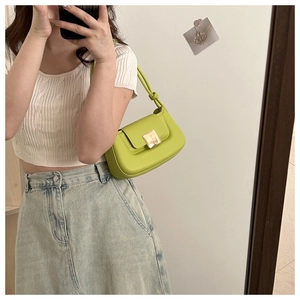 Détail du sac baguette vert lime avec rabat magnétique et boucle carrée dorée