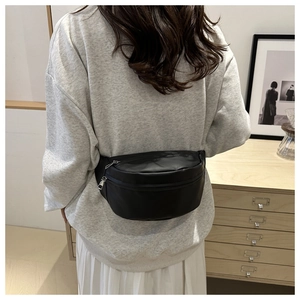 Minimalist black leather belt bag for women showing a stylish crossbody style on a model