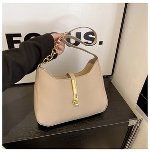 Detail der beigen Hobo-Tasche mit goldenem Metallschloss und Leder-Ketten-Riemen