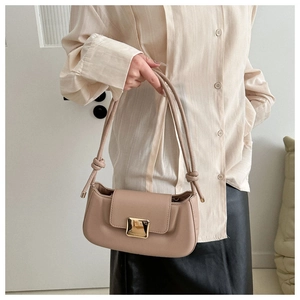Détail du sac baguette beige avec boucle carrée dorée et bandoulière à nœuds