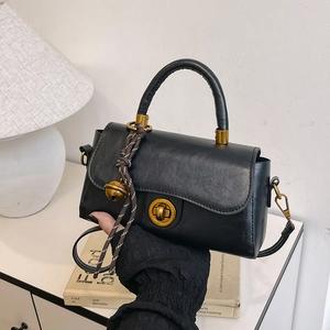 Classic black vintage crossbody bag with golden knob lock and decorative bell pendant