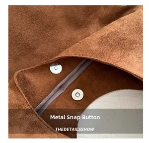 Detail shot of magnetic snap closure and brown suede texture on the large tote bag