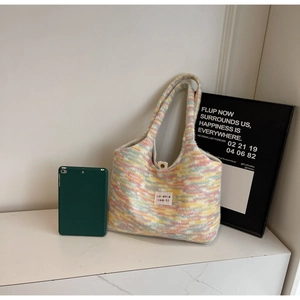 Vista dettagliata di una borsa tote in maglia multicolore con strisce e spalline morbide