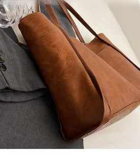 Close-up of a large vintage brown tote bag with wrinkled faux leather texture for commuting