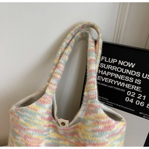 Dettaglio della borsa in maglia a righe arcobaleno con chiusura a bottone a pressione