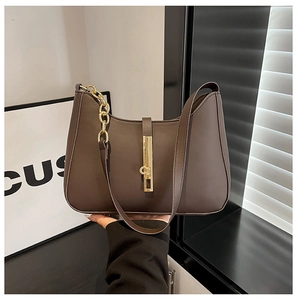 Nahaufnahme einer dunkelbraunen Hobo-Tasche mit goldener Schließe und grober Kettenverzierung