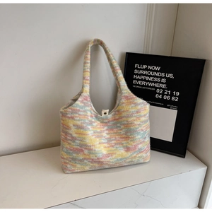 Dettaglio macro della borsa tote in maglia arcobaleno con trama morbida e bottone