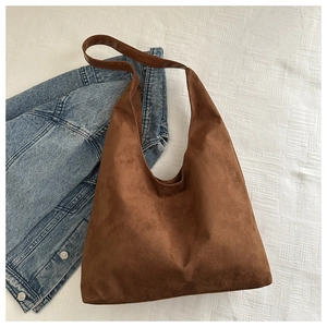 Detail view of large dark brown hobo shoulder bag with matte finish and smooth leather strap