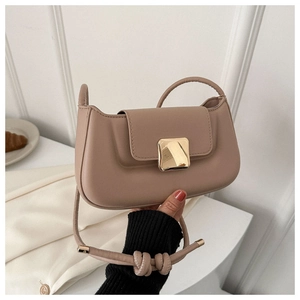 Détail du sac baguette beige minimaliste avec une boucle dorée carrée élégante