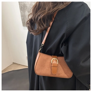 Brown vintage matte crossbody bag with golden horseshoe buckle shown on model
