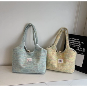 Dettaglio macro della borsa tote in maglia con texture morbida, etichetta e chiusura magnetica