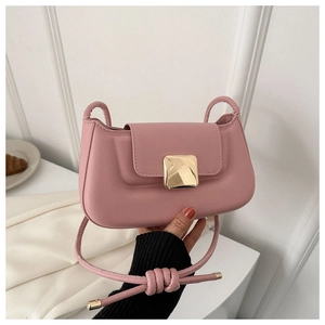 Détail du sac baguette rose en cuir avec une boucle carrée dorée élégante