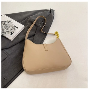 Detail der beigen PU-Leder-Schultertasche mit dekorativem goldenem Kettengurt