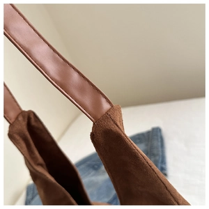 Detail of brown frosted suede tote bag showing leather strap stitching and matte texture