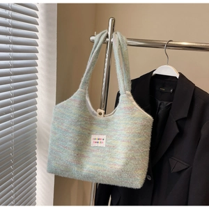 Dettaglio della borsa tote in maglia colorata con trama arcobaleno ed etichetta logo