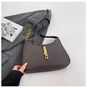 Detailaufnahme einer dunkelbraunen PU-Leder-Schultertasche mit goldenem Metallverschluss