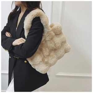 Detail of plush faux fur tote bag showing textured cubic pattern and wide shoulder strap