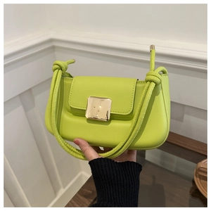 Détail du sac à bandoulière en cuir vert néon avec boucle dorée et design de sangle nouée