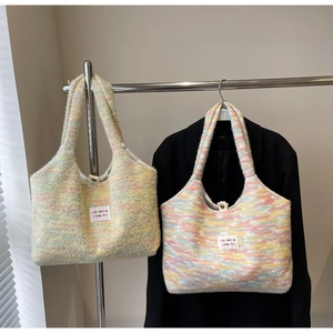 Dettaglio della borsa tote in maglia a righe arcobaleno con etichetta del marchio