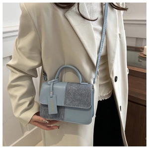 Model wearing a stylish blue leather and grey wool texture crossbody flap handbag