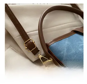 Detail of adjustable metal buckle on light blue denim and brown leather strap