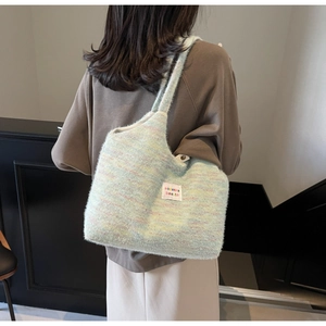 Dettaglio della borsa tote morbida verde in peluche con toppa colorata sulla spalla